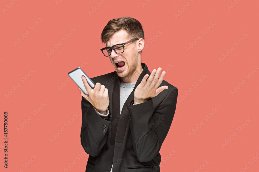 The young caucasian businessman on red background talking on cell phone The young caucasian businessman on red background talking on cell phone