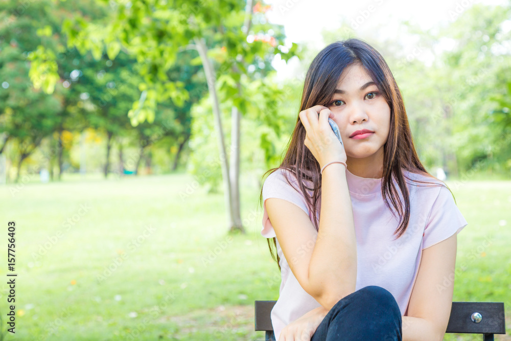 Woman sitting on bench using smartphone in the citypark. Woman sitting on bench using smartphone in the citypark.