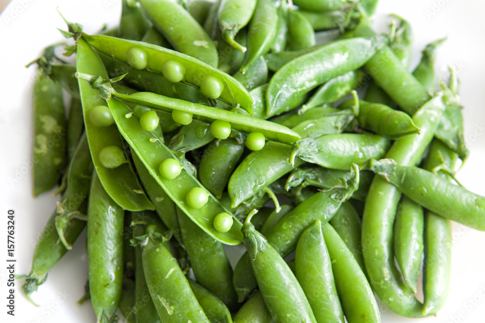 Green peas, close-up on a white background, plate Green peas, close-up on a white background, plate