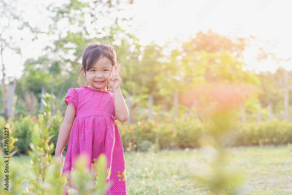 Cute asian child playing in the garden in the summer, little girl in a colorful summer dress, having fun in a beautiful garden,Child having fun outdoors picking fresh flowers. Cute asian child playing in the garden in the summer, little girl in a colorful summer dress, having fun in a beautiful garden,Child having fun outdoors picking fresh flowers.