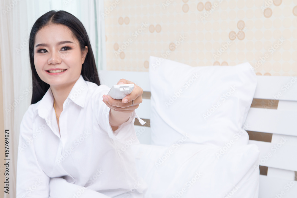 young woman holding remote control of air conditioner, isolated on white background young woman holding remote control of air conditioner, isolated on white background