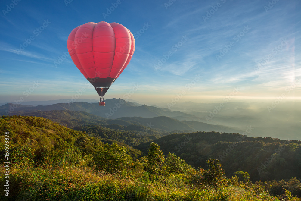 Colorful hot air balloon over the mountain at sunset