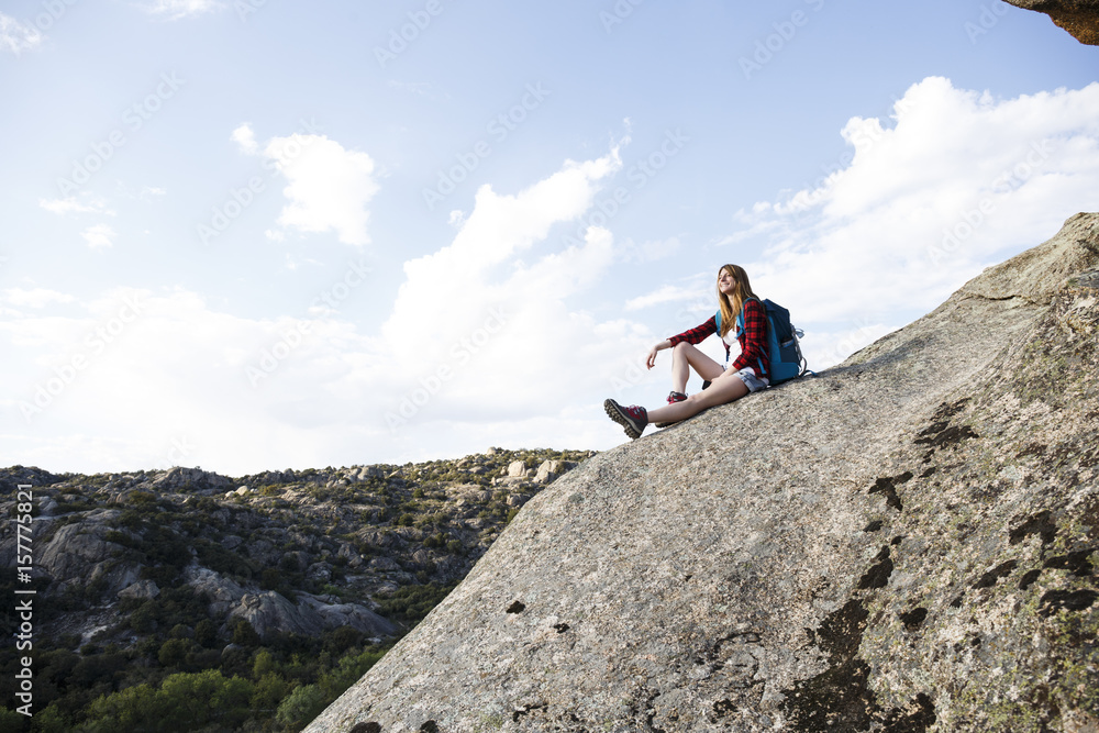Spain, Madrid, young woman resting on a rock during a trekking day