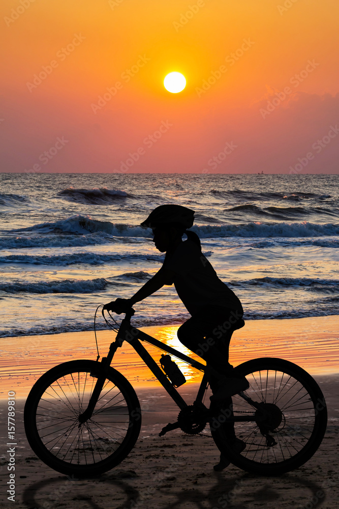 Fototapeta premium People cycling at the beach twilight time