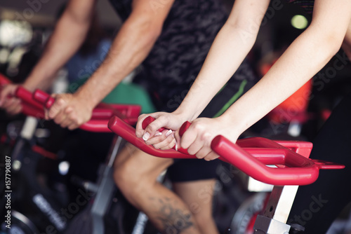 closeup image of man and woman doing spining exercises in a gym