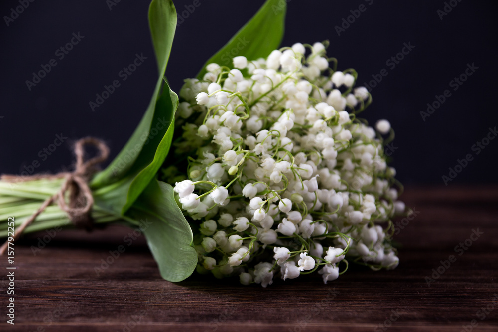 Obraz premium Lily of the valley on wooden background. Lily of the valley bouquet