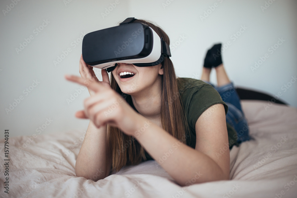 Beautiful young woman enjoying virtual reality at her home. Beautiful young woman enjoying virtual reality at her home.