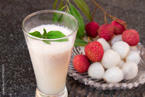 Litchi juice in a glass. Fresh juicy lychee fruit on a glass plate.