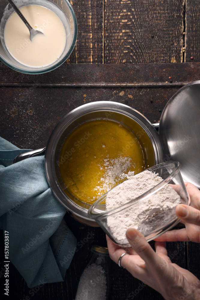 Fototapeta premium Preparation of veloute sauce on the wooden table vertical