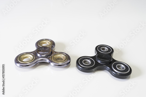 /Image of two different fidget spinners black and purple silver isolated on a white background.