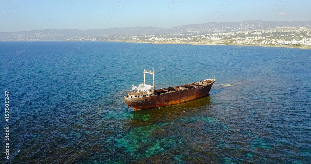 Beautiful seascape with old big, broken, rusty boat near the coast of Peyia, Cyprus. Ship graveyard. Famous landmark in the Mediterranean sea.