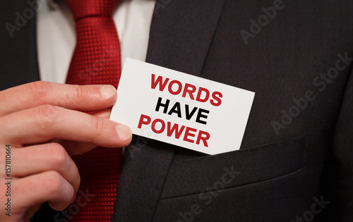 Businessman putting a card with text Words Have Power in the pocket