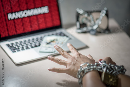 Hands tied up by chains and lock, Hard disk file locked with monitor show ransomware cyber attack internet security breaches on laptop computer