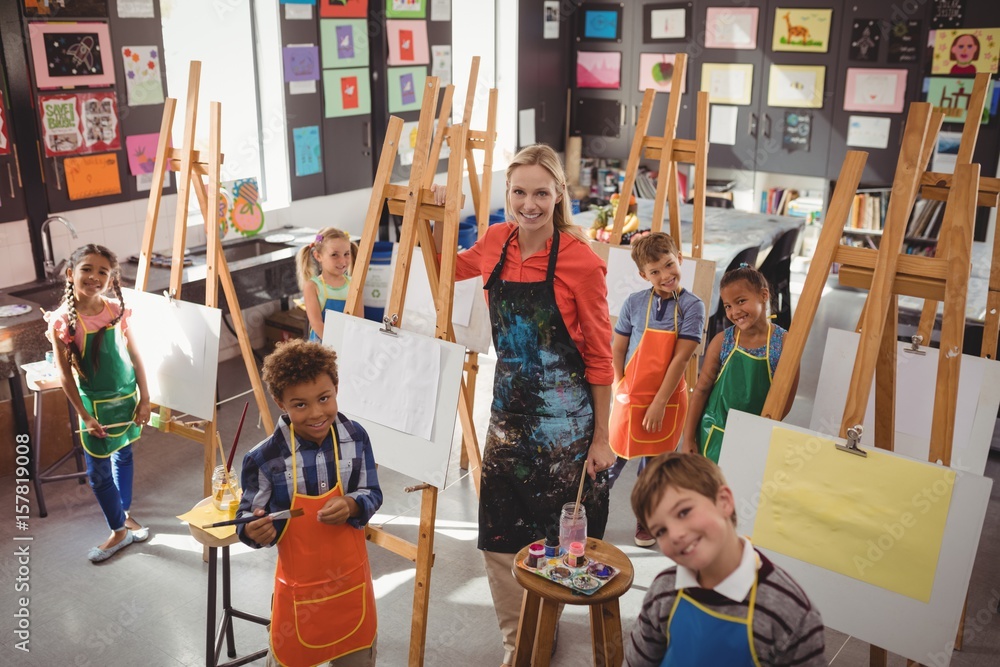 Naklejka premium Teacher and schoolkid standing together in drawing class