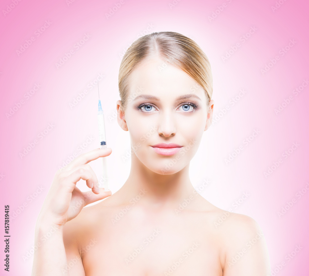 Young, beautiful and healthy woman having skin injections over pink background. Plastic surgery concept.