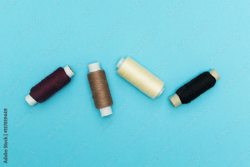 Old rolls of thread on a blue background. Old rolls of thread on a blue background.