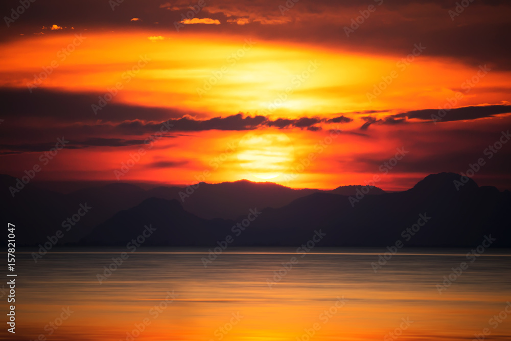 Silhouettes of mountain with sunset at the lake, Thailand.