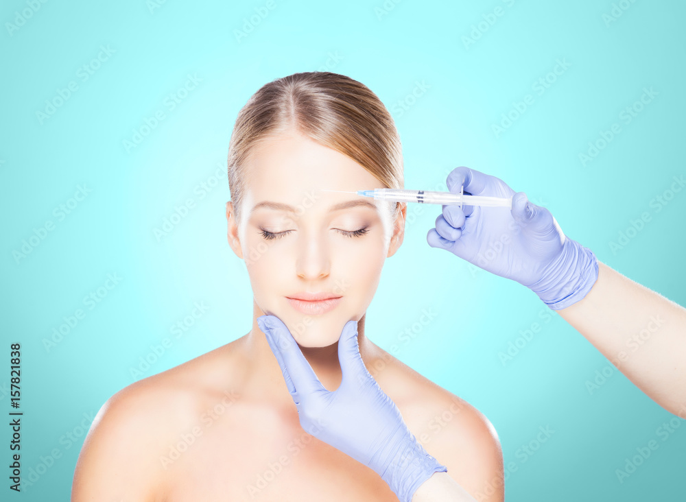 Doctor injecting in a beautiful face of a young woman. Plastic surgery concept. Doctor injecting in a beautiful face of a young woman. Plastic surgery concept.