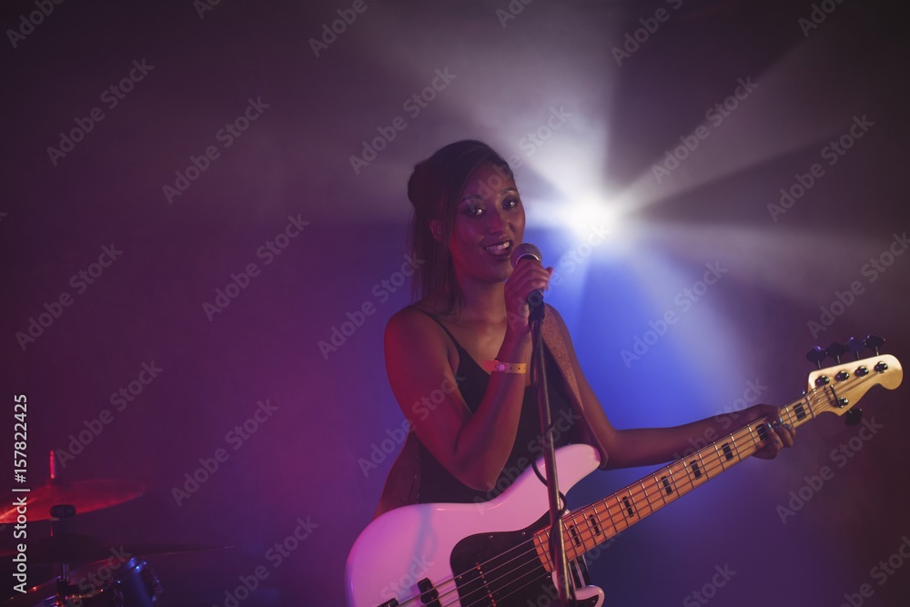 Obraz premium Female singer performing in illuminated nightclub