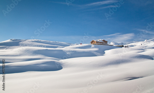 Sunny valley refuge over Santa Caterina Valfurva in winter into the snow