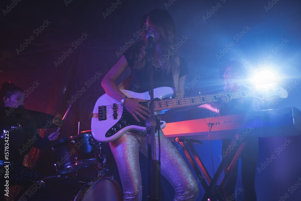 Females performing on illuminated stage in nightclub