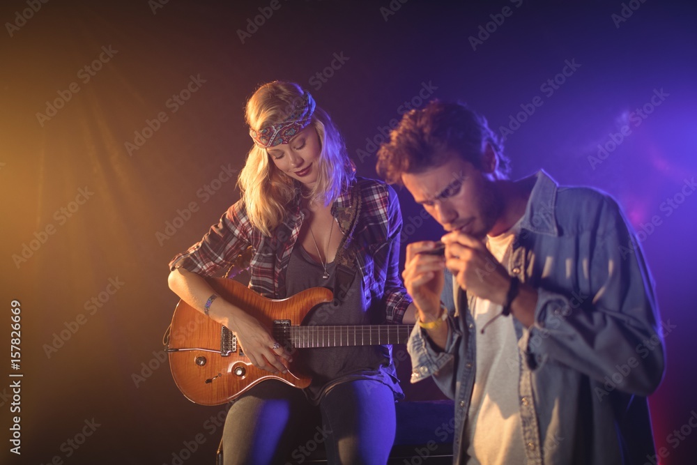 Obraz premium Guitarist performing with musician playing harmonica