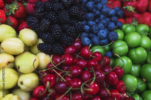Fototapeta Naklejka Na Ścianę i Meble -  Colorful harvest of summer berries and fruits. Top view and soft focus.