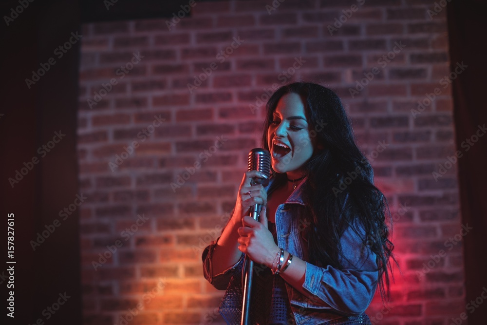 Obraz premium Cheerful singer singing illuminated nightclub
