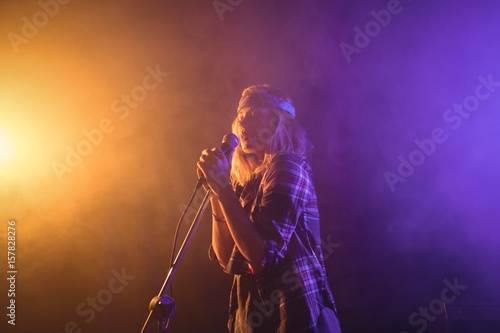 Female singer performing in illuminated nightclub