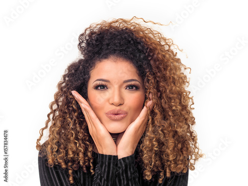 Lovely woman with gorgeous curly hair giving a kiss