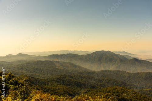 Beautiful landscape of green mountain with clouds fog and golden sky.