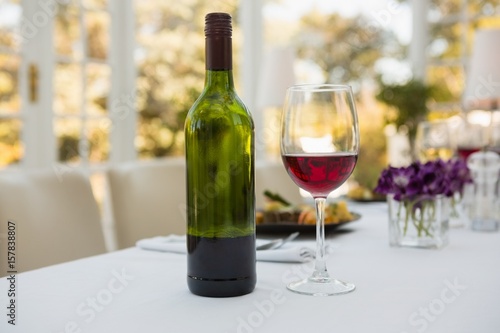 Wineglass and bottle on table in restaurant