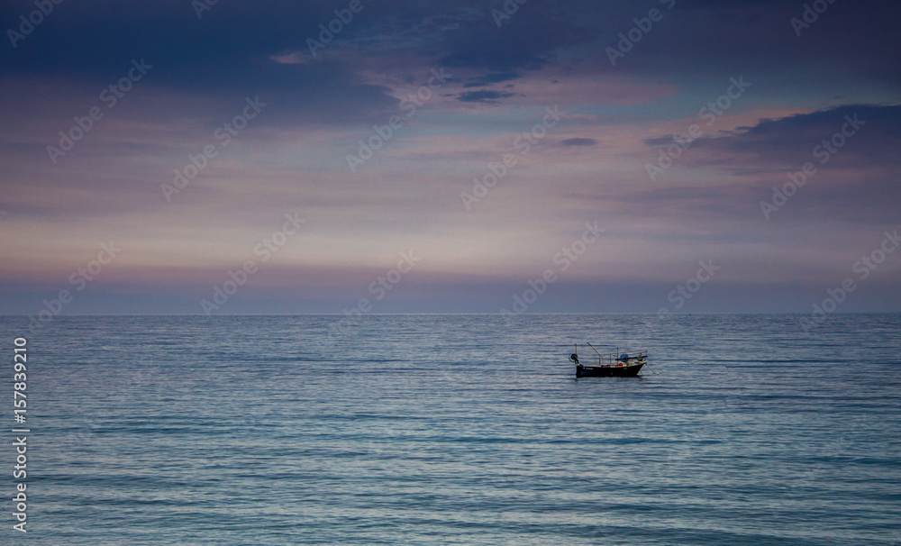 A boat in a Mediterranean beach of Ionian Sea at sunset - Bova Marina, Calabria, Italy A boat in a Mediterranean beach of Ionian Sea at sunset - Bova Marina, Calabria, Italy