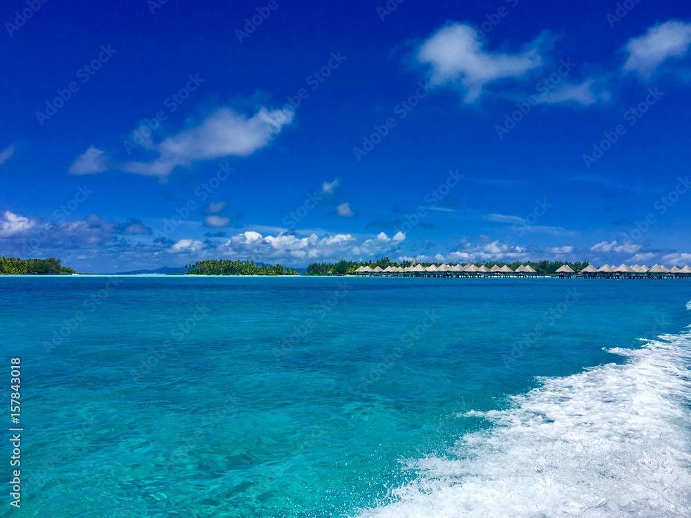 Overwater bungalows of a luxury resort in the turquoise lagoon of Bora Bora, Tahiti, French Polynesia