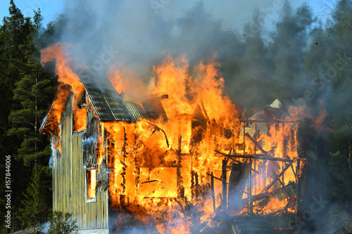 Burning house. Building completely engulfed in flames. 