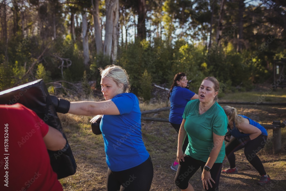 Fototapeta premium Woman practicing boxing in the boot camp