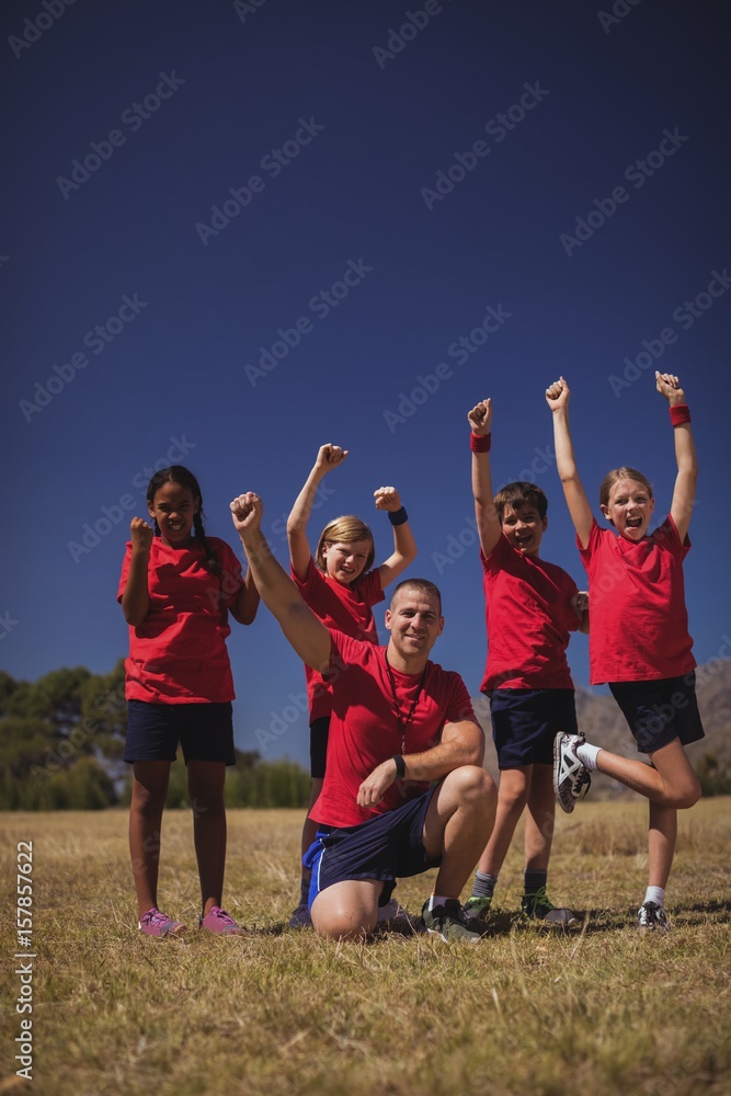 Naklejka premium Trainer and kids relaxing in the boot camp