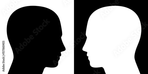 Opposing view - two heads facing each other, one is black on white, the other converse, as a symbol for adverse opinions, contrary ideas, opposite behavior or different beliefs or lifestyle.