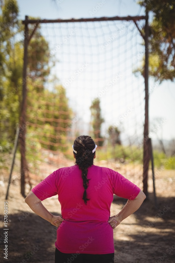Rear view of woman looking at net during obstacle course Rear view of woman looking at net during obstacle course