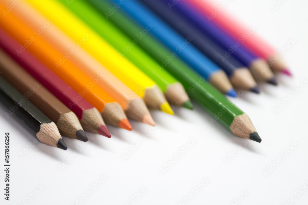 Many colored pencils are on white paper. Many colored pencils are on white paper.