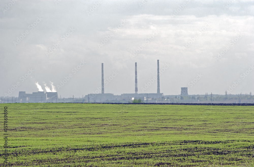 pipe factory smoke on the horizon against the sky with clouds