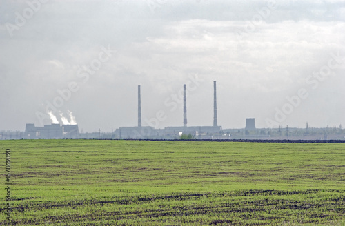 pipe factory smoke on the horizon against the sky with clouds