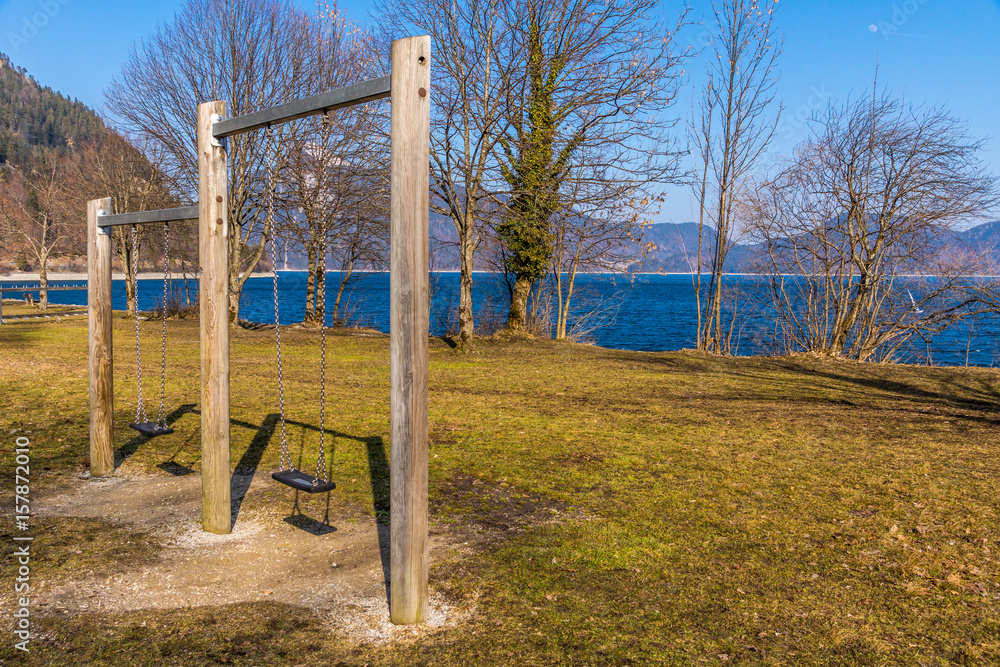 Öffentlicher Park mit Schaukel am Seeufer Öffentlicher Park mit Schaukel am Seeufer