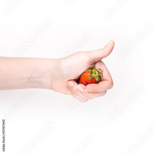 Close up of woman hand holding one strawberry isolated on white background.