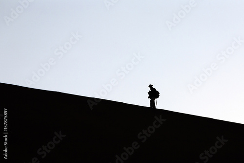 Profile of a hiker on the sand dune shaped by the wind Deadvlei Sossusvlei Namib Desert Naukluft National Park Namibia Africa