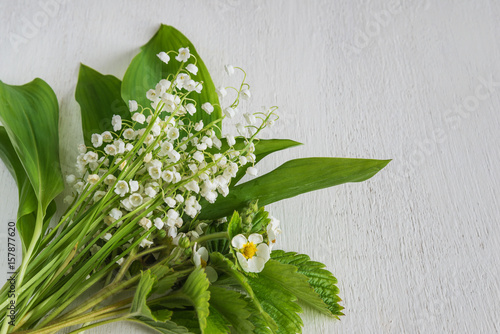 bouquet of lily of the valley flowers on white wooden background
