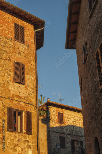 Montichiello - Italy, October 29, 2016: Quiet street in Montichiello, Tuscany with typical shuttered windows and paved streets. Monticchiello is the only fraction of the municipality of Pienza, in th