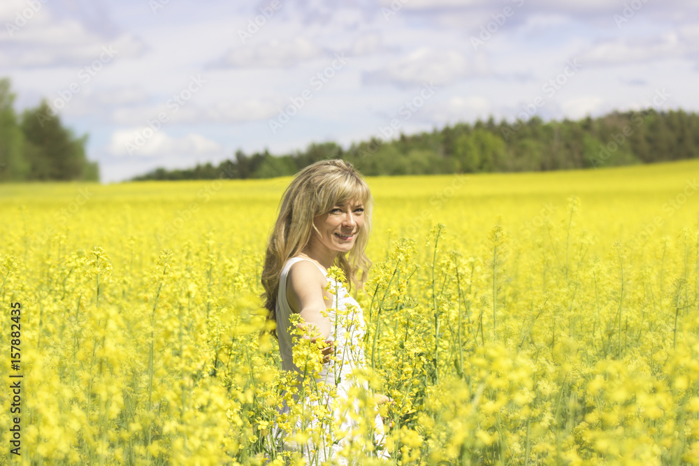 Woman with long hair, yellow rapeseed canola field enjoying nature and sunlight. Woman with long hair, yellow rapeseed canola field enjoying nature and sunlight.