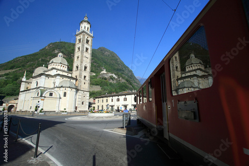 The Bernina Express passing by the Sanctuary of the Madonna in Tirano, Valtellina, Italy Europe