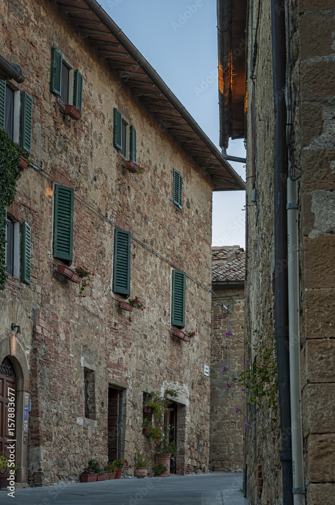 Montichiello - Italy, October 29, 2016:  Quiet street in Montichiello, Tuscany with typical shuttered windows and paved streets. Monticchiello is the only fraction of the municipality of Pienza, in th